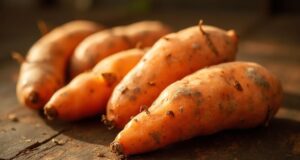 Close-up de batatas-doces laranja assadas numa bancada de madeira